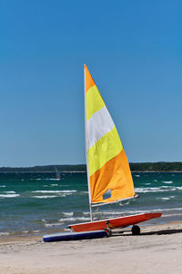 Colorful sailboat on trailer and rubber dinghy on beach along the shores of georgian bay