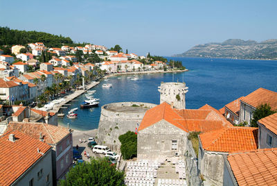 High angle view of townscape by sea against sky