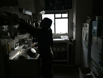 Side view of silhouette man standing at home