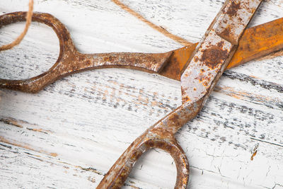 Directly above shot of rusty scissors on wooden table