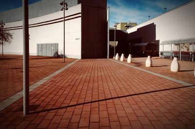 Empty street amidst buildings in city against sky