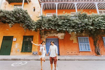 Couple standing on road by building