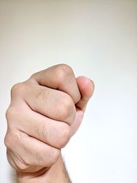 Close-up of human fist over white background