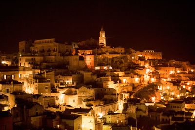 Illuminated cityscape against sky at night