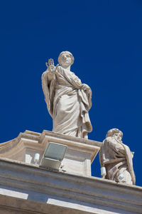 Low angle view of statue against blue sky