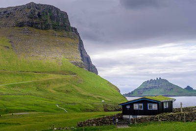 Scenic view of house and mountains against sky