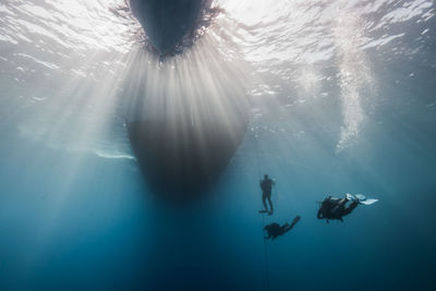 Low angle view of people swimming in sea