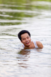 Portrait of smiling boy swimming in water