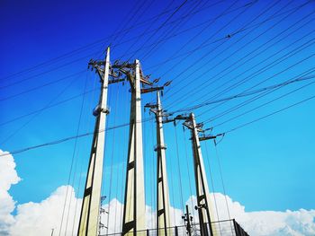 Low angle view of telephone pole against blue sky