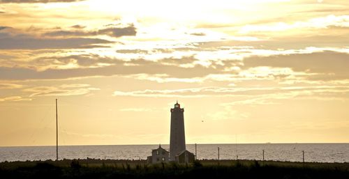 Lighthouse at seaside during sunset