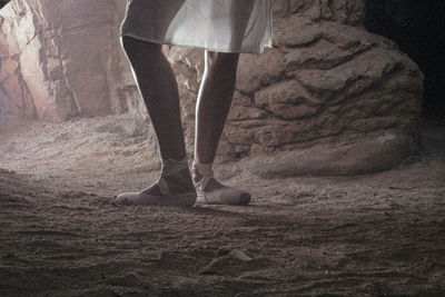 Low section of ballet danger standing in cave