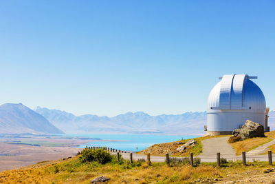 Built structure on landscape against blue sky