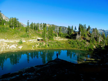 Male hiker standing by alpine lake in north cascades national park