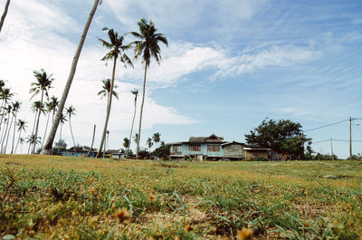 View of field against cloudy sky