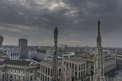 View of cityscape against cloudy sky