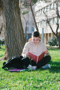 Full length of young man reading book in park