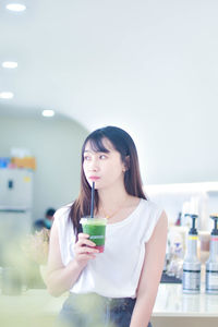 Portrait of young woman drinking glass