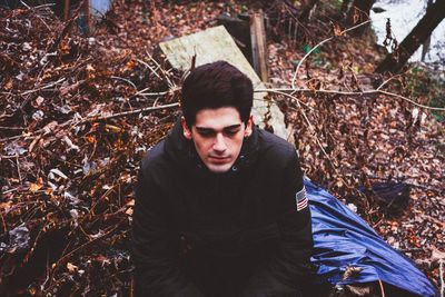 Portrait of young man standing in forest during autumn