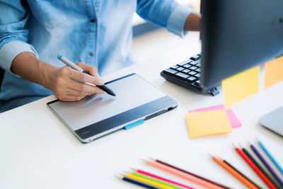 Midsection of man using laptop on table