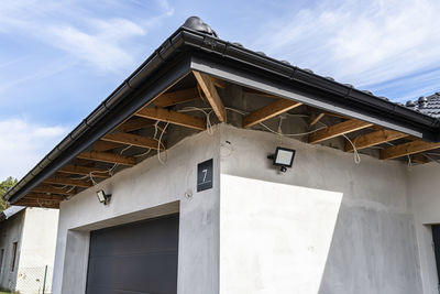 The light for the motion sensor mounted on the facade of the building above the garage door 