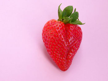 Close-up of strawberry heart shape against red background
