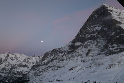 Low angle view of snowcapped mountain against sky