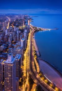 High angle view of illuminated city at waterfront