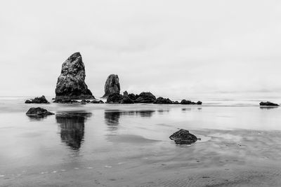 Rocks on sea shore against sky