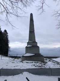 Built structure on snow covered field against sky