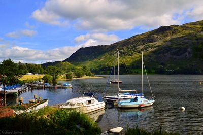 Boats in sea with mountain range in background