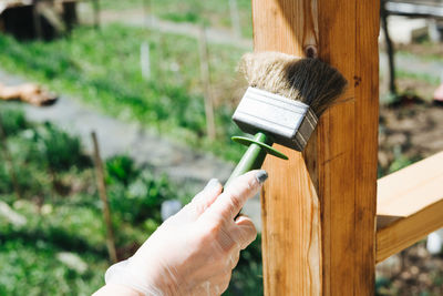 Covering the protective varnish of the wooden terrace. there's a big paintbrush in your hand.