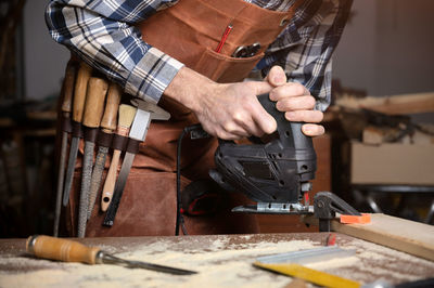 Midsection of man working in workshop