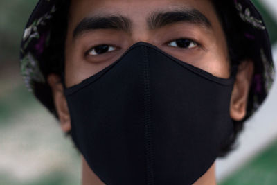 Close-up portrait of young woman covering face