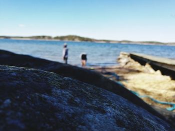 Close-up of rocks in sea against clear sky