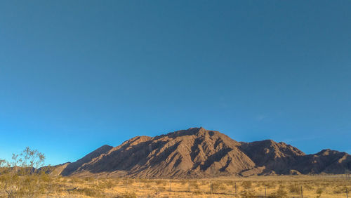 Scenic view of mountains against clear blue sky