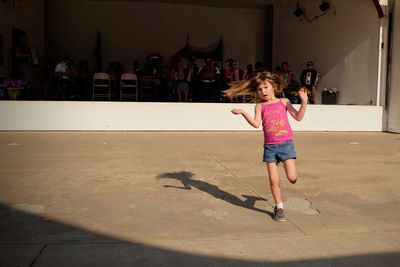 Full length of woman jumping against the wall