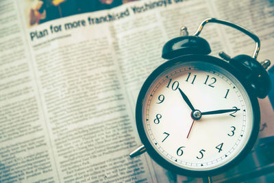 High angle view of alarm clock on newspaper