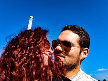 Close-up of couple wearing sunglasses against sky