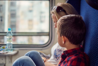 Boy sitting with mother in train