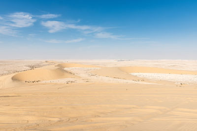 Sand dunes in desert against sky