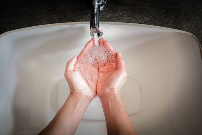 High angle view of person washing hands in sink