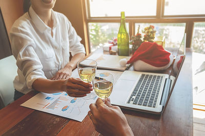 Midsection of woman using smart phone on table