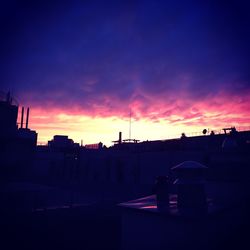 Silhouette of city against sky during sunset