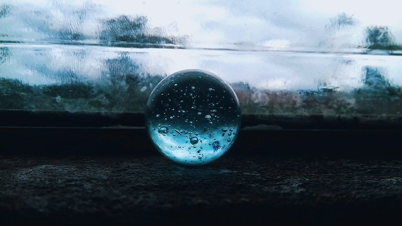 glass - material, sphere, close-up, nature, no people, transparent, focus on foreground, water, outdoors, day, geometric shape, selective focus, wet, single object, reflection, drop, sky, ball, circle, rain, surface level, raindrop