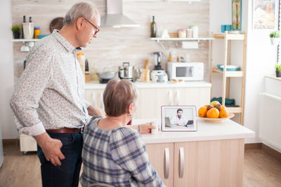 Rear view of people having food at home