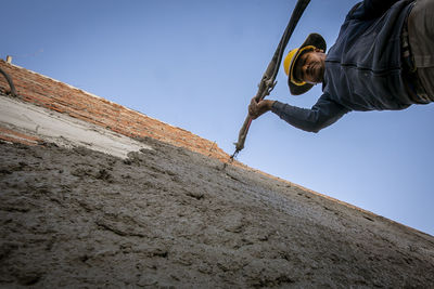 Low angle view of man climbing on rock