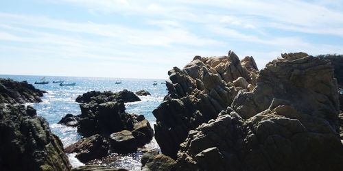 Rocks on beach against sky