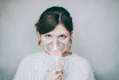 Portrait of woman drinking water from wall