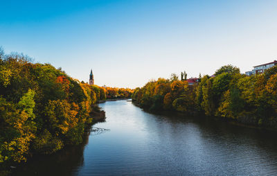 Scenic view of river against clear sky during autumn