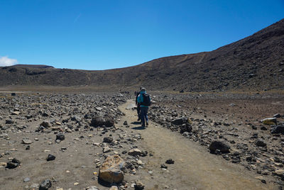Rear view of man on mountain against sky